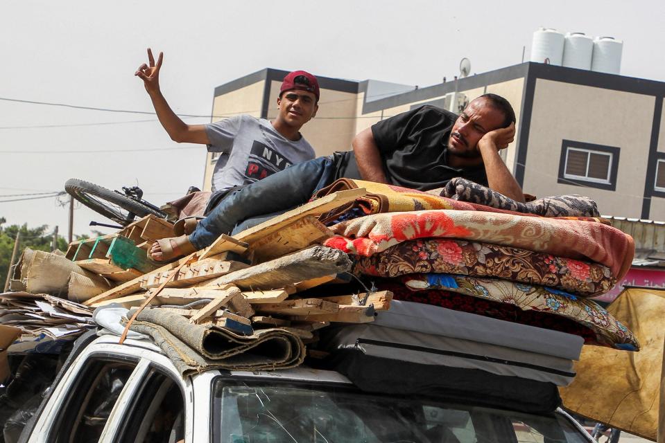 A Palestinian man gestures as another rests atop a vehicle loaded with belongings while they flee Rafah, after Israeli forces launched a ground and air operation in the eastern part of the southern Gaza city (REUTERS)