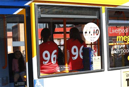 Fans with shirts representing the 96 victims travel on a bus before a memorial service to mark the 25th anniversary of the Hillsborough disaster at Anfield in Liverpool, northern England April 15, 2014. REUTERS/Darren Staples