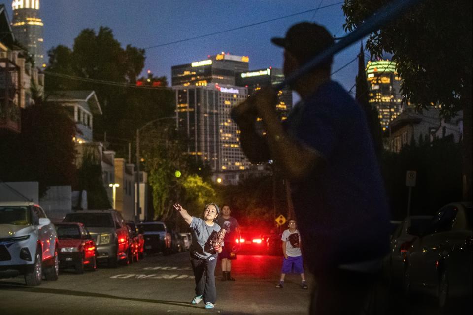 Isabel Arriaga, 16, pitches a Wiffle Ball to her dad, George Arriaga.