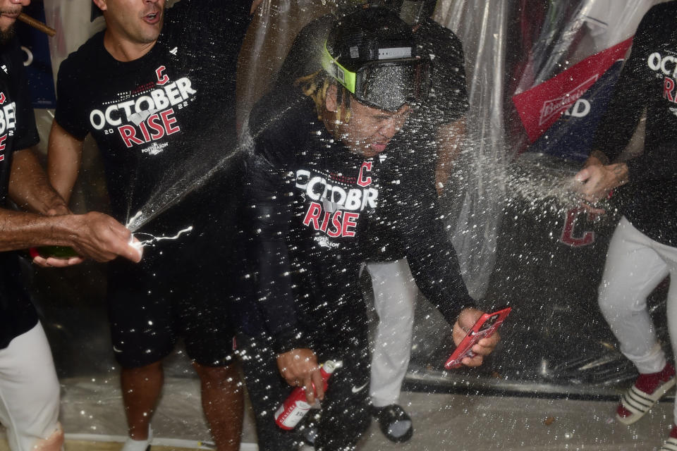 El dominicano José Ramírez, es empapado con champaña y cerveza en el clubhouse de los Guardianes de Cleveland, tras eliminar a los Rays de Tampa Bay en el encuentro del sábado 8 de octubre de 2022 (AP Foto/David Dermer)