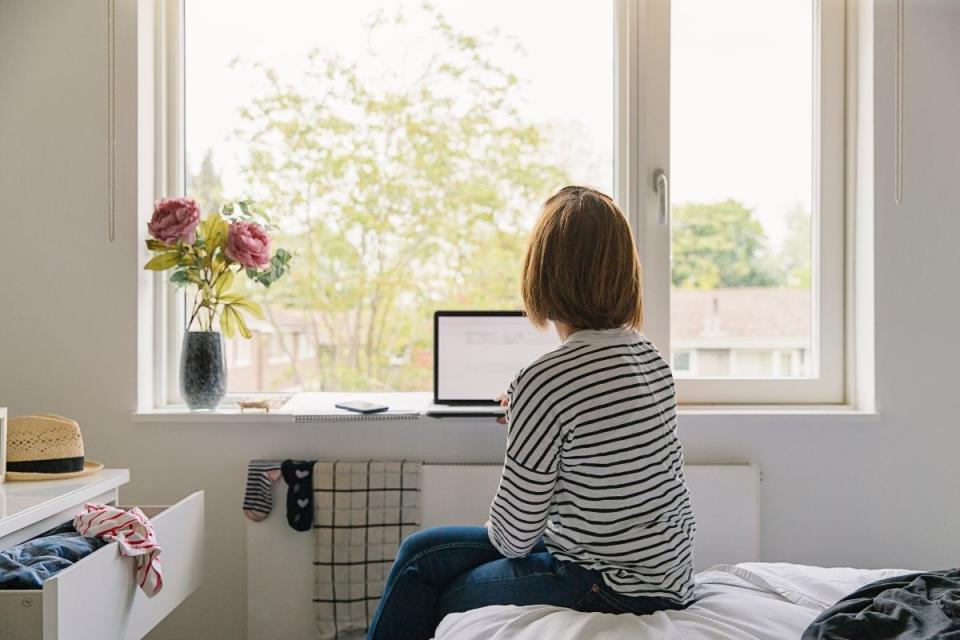 A woman works from windowsill during lockdown.