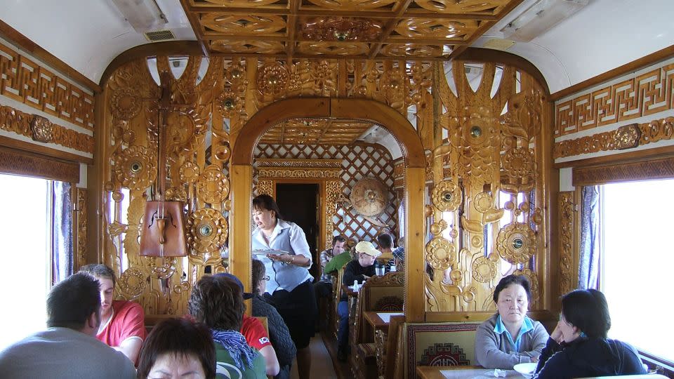 The dining car on the Trans-Mongolian Railway features beautifully carved wooden decor. - Edd Westmacott/Alamy Stock Photo