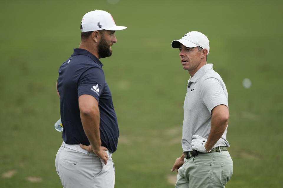 Jon Rahm, left, of Spain, talks with Rory McIlroy, of Northern Ireland, on the practice range during a practice round in preparation for the Masters golf tournament at Augusta National Golf Club Tuesday, April 9, 2024, in Augusta, Ga. (AP Photo/Charlie Riedel)