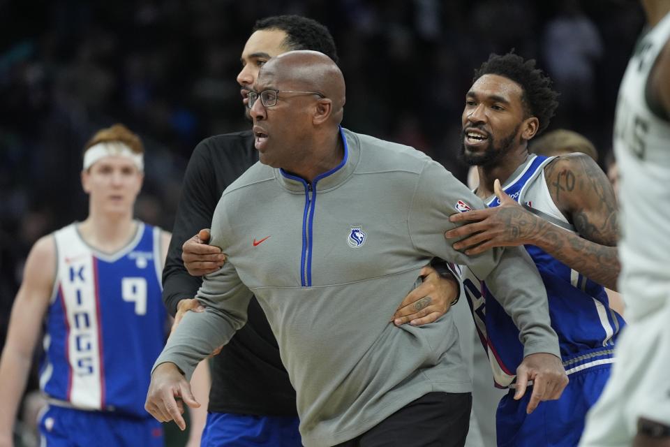 Sacramento Kings head coach Mike Brown is restrained bt Malik Monk as he argues a call during the second half of an NBA basketball game against the Milwaukee Bucks Sunday, Jan. 14, 2024, in Milwaukee. The Bucks won 143-142 in overtime. (AP Photo/Morry Gash)