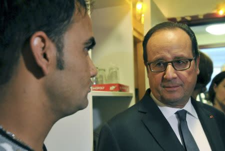 French President Francois Hollande listens to an Afghan migrant at a shelter and orientation centre in Tours, France, September 24, 2016. REUTERS/ Guillaume Souvant/Pool