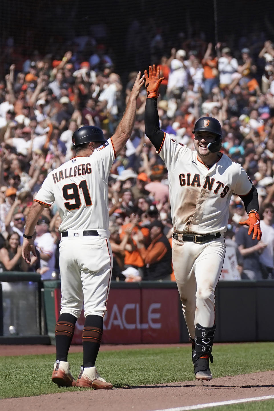 San Francisco Giants' Patrick Bailey, right, is congratulated by third base coach Mark Hallberg (91) after hitting a two-run home run during the tenth inning of a baseball game against the Texas Rangers in San Francisco, Sunday, Aug. 13, 2023. (AP Photo/Jeff Chiu)