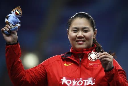 Zhang Wenxiu of China holds her medal as she smiles at the women's hammer throw victory ceremony during the IAAF World Athletics Championships at the Luzhniki stadium in Moscow August 16, 2013. REUTERS/Maxim Shemetov