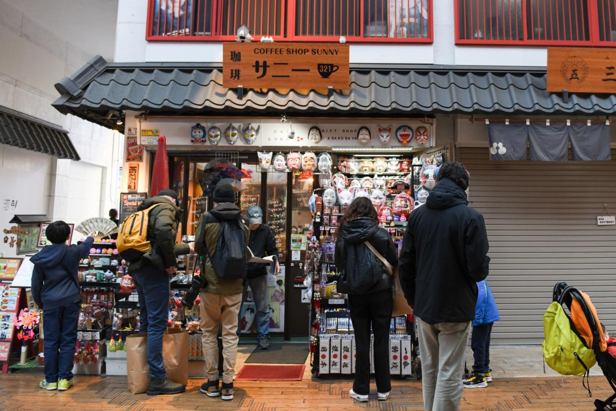 Visitors in front of a coffee shop in the Asakusa district of Tokyo, Japan, on Tuesday, Dec. 26, 2023. 