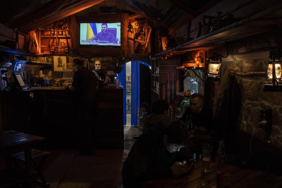 Ukrainian President Volodymyr Zelenskyy appears on the television inside a bar in downtown Lviv, western Ukraine, Tuesday, March 22, 2022. Ukrainian forces fought off continuing Russian efforts to occupy Mariupol and claimed to have retaken a strategic suburb of Kyiv on Tuesday, mounting a defense so dogged that it is stoking fears Russia's Vladimir Putin will escalate the war to new heights. (AP Photo/Bernat Armangue)