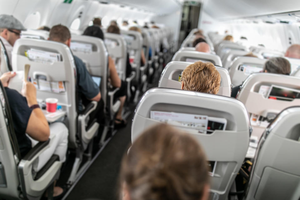 Interior of commercial airplane with passengers in their seats during flight.