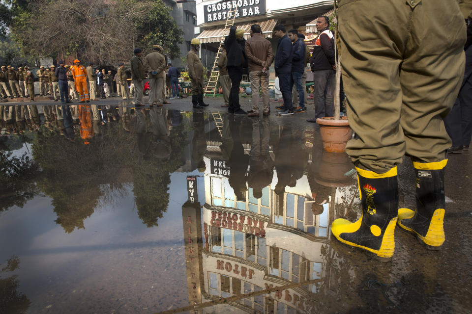 The Arpit Palace Hotel is reflected in a puddle after an early morning fire at the hotel killed more than a dozen people in the Karol Bagh neighborhood of New Delhi, India, Tuesday, Feb.12, 2019. (AP Photo/Manish Swarup)