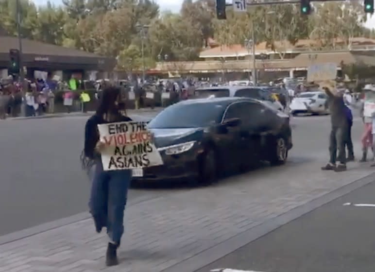 A frame grab from a Instagram video of a rally against anti-Asian hate in Diamond Bar Sunday shows a car driving through a group of protestors while yelling at them, triggering a law enforcement investigation.