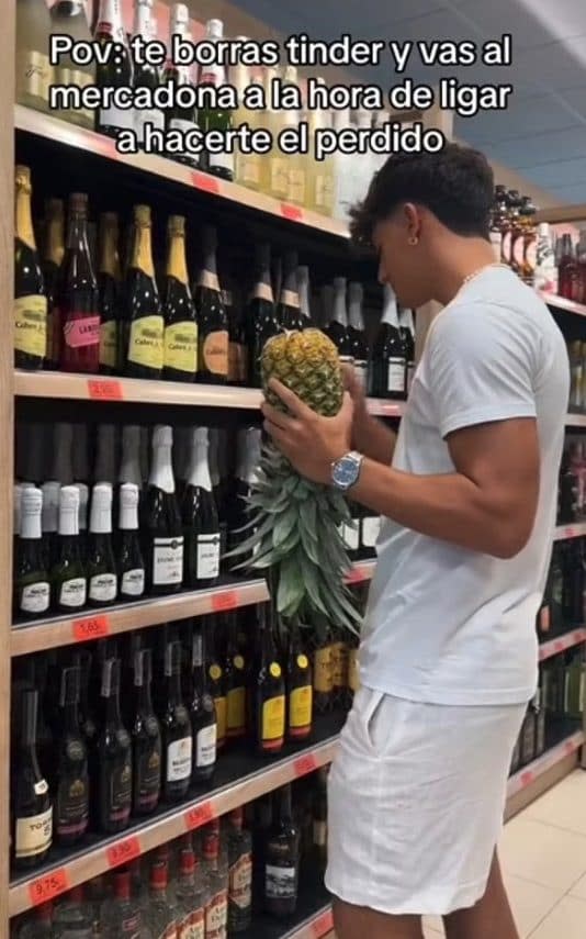 A young Spaniard shows off his pineapple in a supermarket