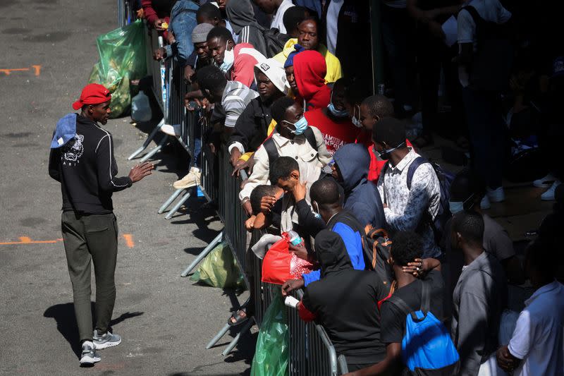 Migrantes recién llegados a Nueva York esperan frente al Hotel Roosevelt