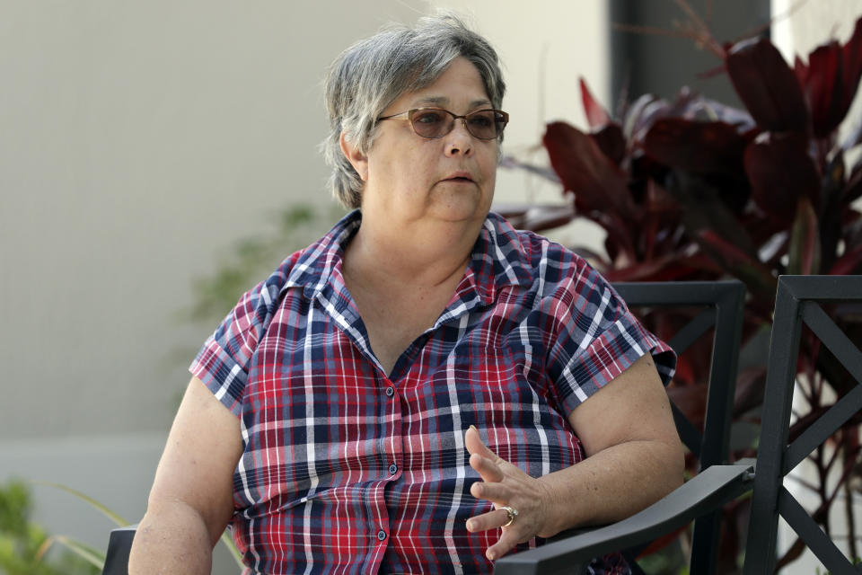 In this Thursday, March 19, 2020 photo, Cathie Hardy, at her home, discusses current issues living in a retirement community in The Villages, Fla. Due to the coronavirus all regularly-scheduled indoor activities were canceled through the end of the month for residents living in what is perhaps the largest concentration of seniors in the U.S. (AP Photo/John Raoux)