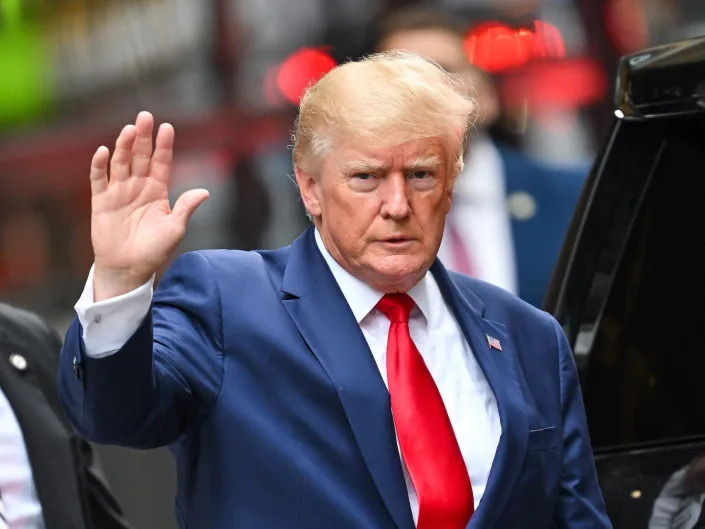 Former US President Donald Trump waves to photographers camped outside Trump Tower as he leaves to meet with New York Attorney General Letitia James for a civil investigation on August 10, 2022 in New York City.