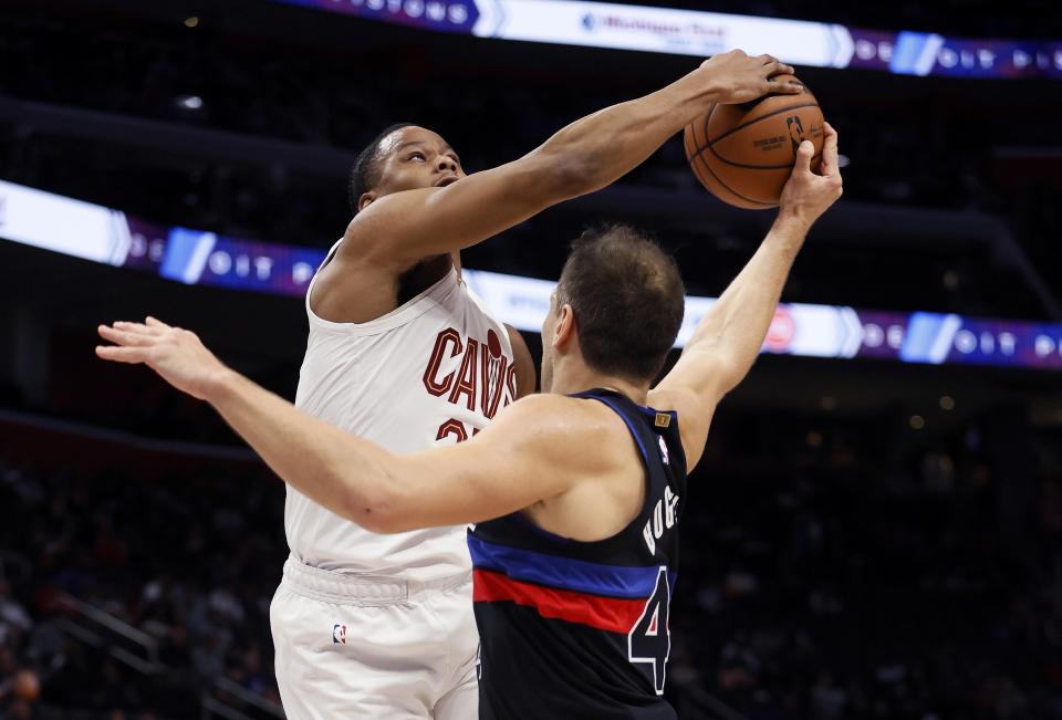 Cleveland Cavaliers forward Isaac Okoro, left, steals the ball from Detroit Pistons forward Bojan Bogdanovic, right, during the first half of an NBA basketball game Saturday, Dec. 2, 2023, in Detroit. (AP Photo/Duane Burleson)