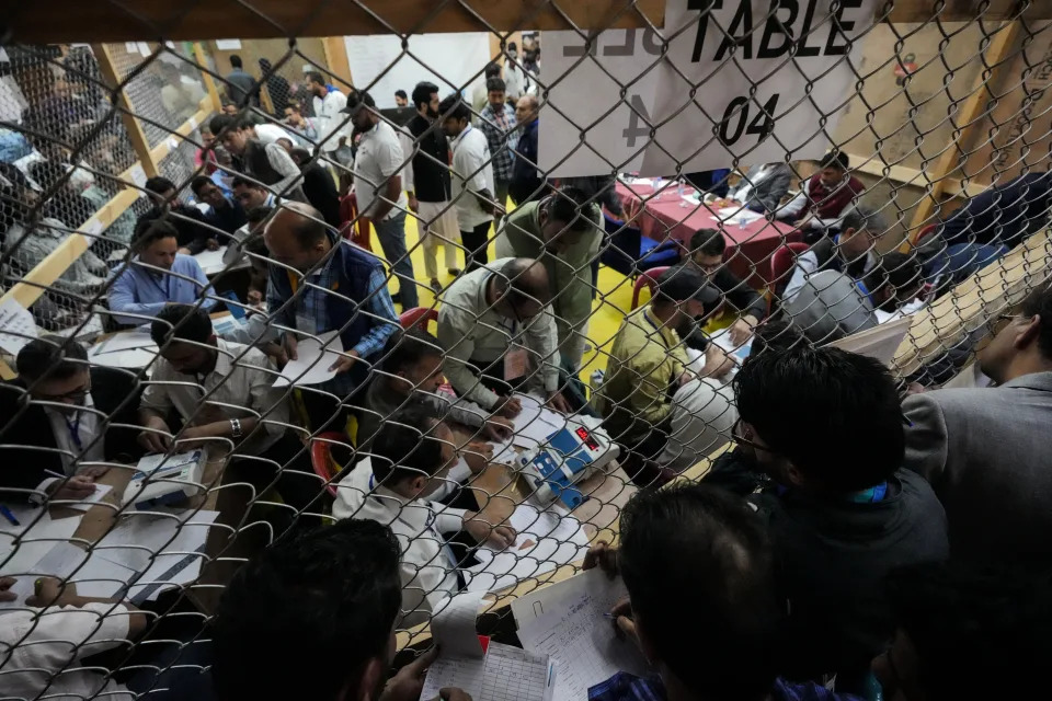 Political party representatives watch as polling officials count the votes in the recent election for a local government in Indian-controlled Kashmir on the outskirts of Srinagar, Tuesday, Oct. 8, 2024. (AP Photo/Mukhtar Khan)