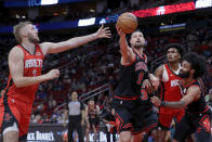 Chicago Bulls center Nikola Vucevic (9) gets a rebound before Houston Rockets center Jock Landale, left, in front o Rockets forward Amen Thompson, second from right, and guard Coby White, right, during the first half of an NBA basketball game Thursday, March 21, 2024, in Houston. (AP Photo/Michael Wyke)