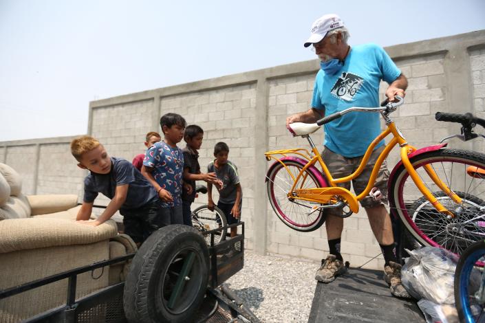 Las Cruces native Chet Wright, far right, hands kids donated bikes he is going to give out to other children in a colonia on the outskirts of Ciudad Ju&#xe1;rez  Monday, July 12, 2021. Wright drives to the colonia twice a month to deliver refurbished bikes to the kids in the area through his nonprofit, &quot;Bikes for Ju&#xe1;rez .&quot;