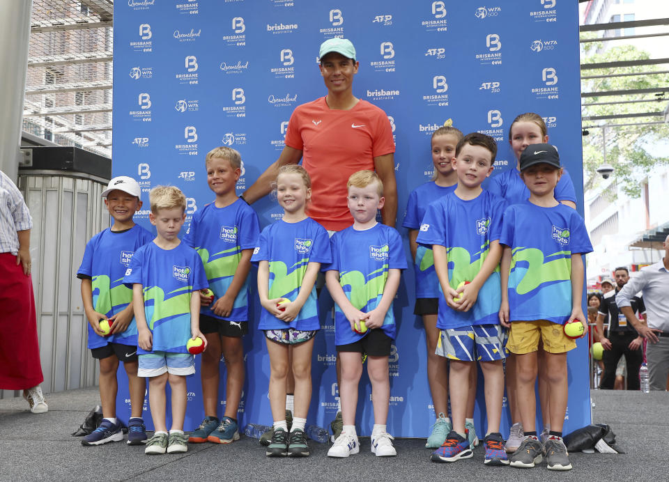 Rafael Nadal of Spain poses with some young players during a public appearance in the Queen Street Mall ahead of the Brisbane International tennis tournament in Brisbane, Australia, Friday, Dec. 29, 2023. (AP Photo/Tertius Pickard)