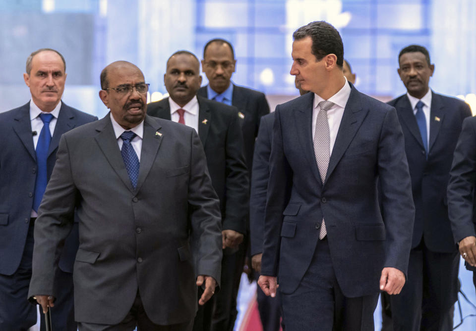 FILE - In this file photo released by the Syrian official news agency SANA Dec. 16, 2018, Syrian President Bashar Assad, right, meets with Sudan's President Omar Bashir in Damascus, Syria. Assad has survived years of war and millions of dollars in money and weapons aimed at toppling him. Now after nearly eight years of conflict, he is poised to be readmitted to the fold of Arab nations, a feat once deemed unthinkable as he brutally crushed a years-long uprising against his family’s rule. (SANA via AP, File)
