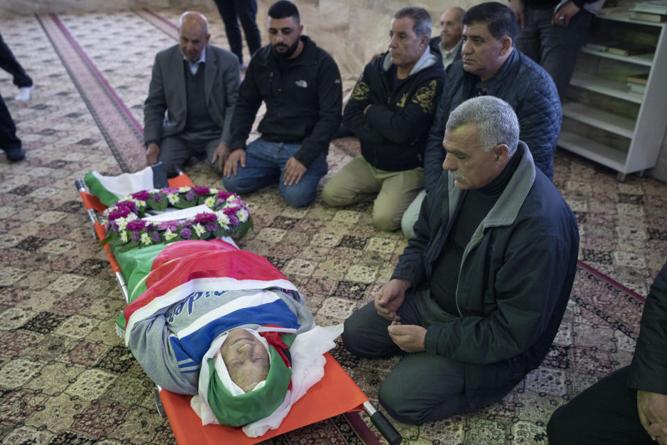 FILE - Mourners pray by the body of 78-year-old Omar Assad, a Palestinian who has U.S. citizenship, during his funeral at a mosque, in the West Bank village of Jiljiliya, north of Ramallah, Jan. 13, 2022. Two members of Wisconsin's congressional delegation asked the Biden administration Monday, Jan. 31, 2022, to investigate how a Palestinian-American who lived in Milwaukee before moving back to his home village died at a West Bank checkpoint. Assad, 78, died after Israeli troops stopped him at a checkpoint in his native village of Jiljilya during the early morning hours of Jan. 12, according to family members and media reports. (AP Photo/Nasser Nasser, File)