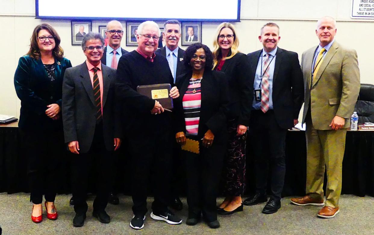 The Apple Valley Unified School District Board and administration recently honored Trustee Dennis Bender with a plaque and specially designed portable seat for visits to the planned sports stadium at Granite Hills High School.