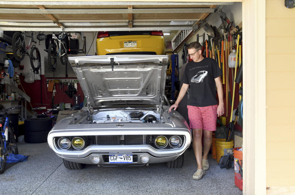 Kevin Erickson walks around his electrified 1972 Plymouth Satellite at his Commerce City, Colo., home on Sept. 20, 2022. Erickson is part of a small but expanding group of tinkerers, racers, engineers, and entrepreneurs across the country converting vintage cars and trucks into greener, and often much faster, electric vehicles. (AP Photo/Thomas Peipert)