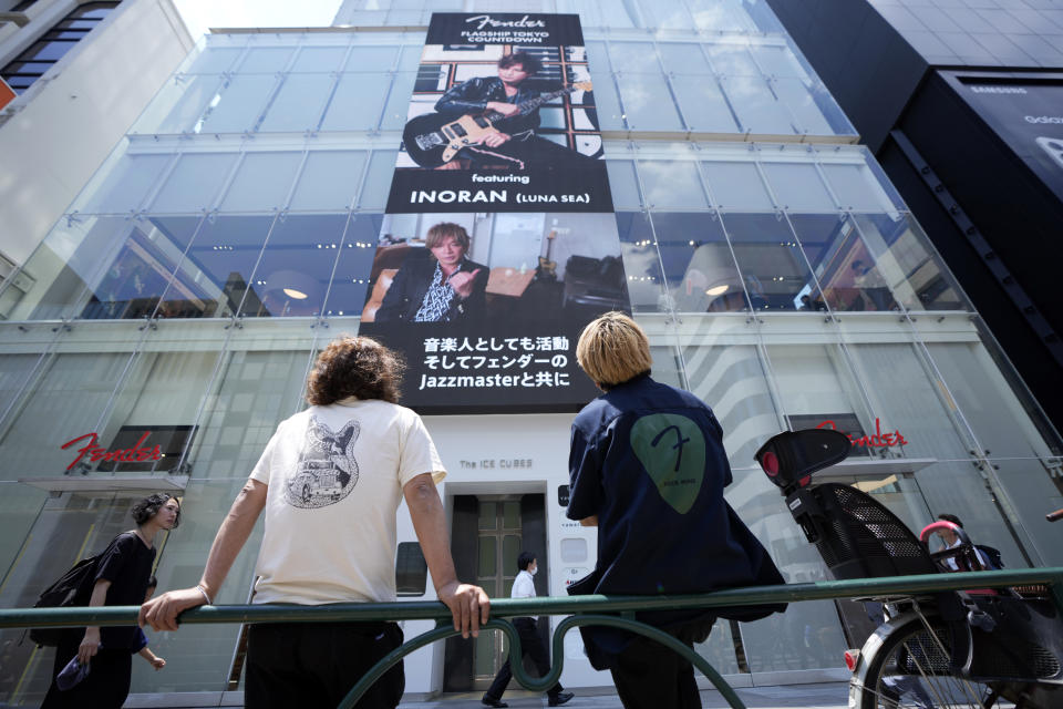 Staff members of Fender's Tokyo store look at its store building Thursday, June 29, 2023. Fender, the guitar of choice for some of the world’s biggest stars from Jimi Hendrix to Eric Clapton, is opening what it calls its “first flagship store” in its 77-year history. (AP Photo/Eugene Hoshiko)
