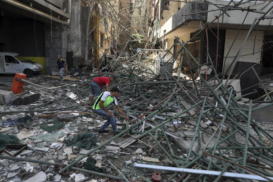 Workers remove rubble from damaged buildings near the site of an explosion on Tuesday that hit the seaport of Beirut, Lebanon, Thursday, Aug. 6, 2020. The blast which appeared to have been caused by an accidental fire that ignited a stockpile of ammonium nitrate at the port, rippled across the Lebanese capital, killing at least 135 people, injuring more than 5,000 and causing widespread destruction. (AP Photo/Bilal Hussein)