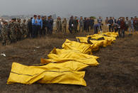 <p>Nepalese rescuers attend to bodies of victims after a passenger plane from Bangladesh crashed at the airport in Kathmandu, Nepal, March 12, 2018. (Photo: Niranjan Shreshta/AP) </p>