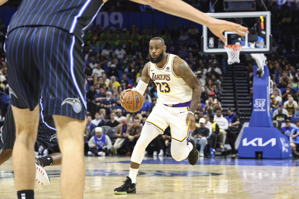 Los Angeles Lakers forward LeBron James brings the ball up during the first half of the team's NBA basketball game against the Orlando Magic, Saturday, Nov. 4, 2023, in Orlando, Fla. (AP Photo/Gary McCullough)