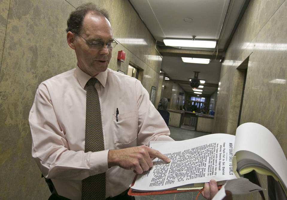 Senior Court Clerk Robert Smith shows a 1920 newspaper article, one of his collection about night court, in New York's Criminal Court Building, Tuesday evening March 11, 2014. Night court is one of New York’s more peculiar and paradoxical tourist traditions, a place visitors extol on travel websites while many residents hope never to wind up there. To travelers, it’s gritty entertainment, hard-knocks education or at least a chance to experience real-life law and order on a New York scale. (AP Photo/Richard Drew)