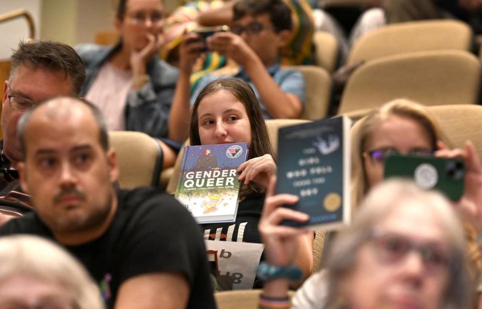 Audience members hold up signs as a speaker addresses the Charlotte Mecklenburg school board on Aug. 22, 2023 prior to its 7-2 vote to approve four policies that comply with North Carolina’s Parents’ Bill of Rights.