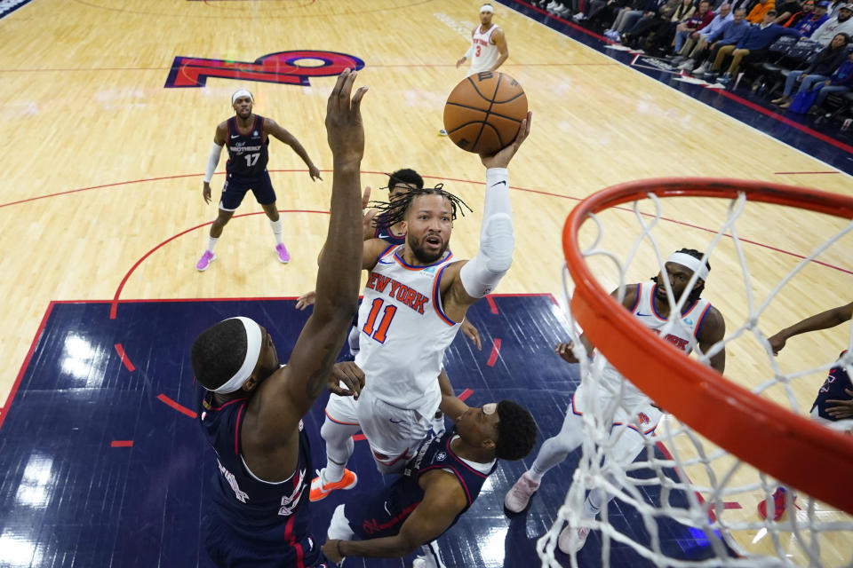 New York Knicks' Jalen Brunson, center, goes up for a shot against Philadelphia 76ers' Paul Reed, left, and Kyle Lowry during the second half of an NBA basketball game, Thursday, Feb. 22, 2024, in Philadelphia. (AP Photo/Matt Slocum)