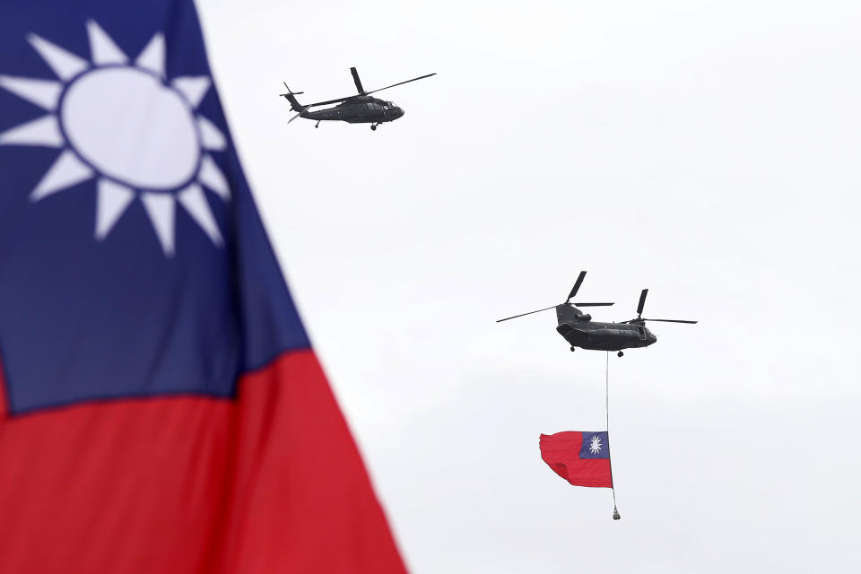 Helicopters fly over President Office with Taiwan National flag during the National Day celebrations in Taipei, Taiwan, Saturday, Oct. 10, 2020. Taiwanese President Tsai Ing-wen said Saturday she has hopes for less tensions with China and in the region if Beijing will listen to Taipei’s concerns, alter its approach and restart dialogue with the self-ruled island democracy. (AP Photo/Chiang Ying-ying)