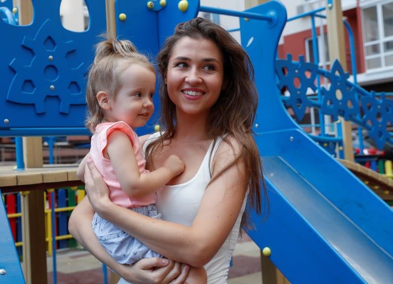 Olena Kudryashova and her daughter Maya smile before an interview with Reuters in Kiev