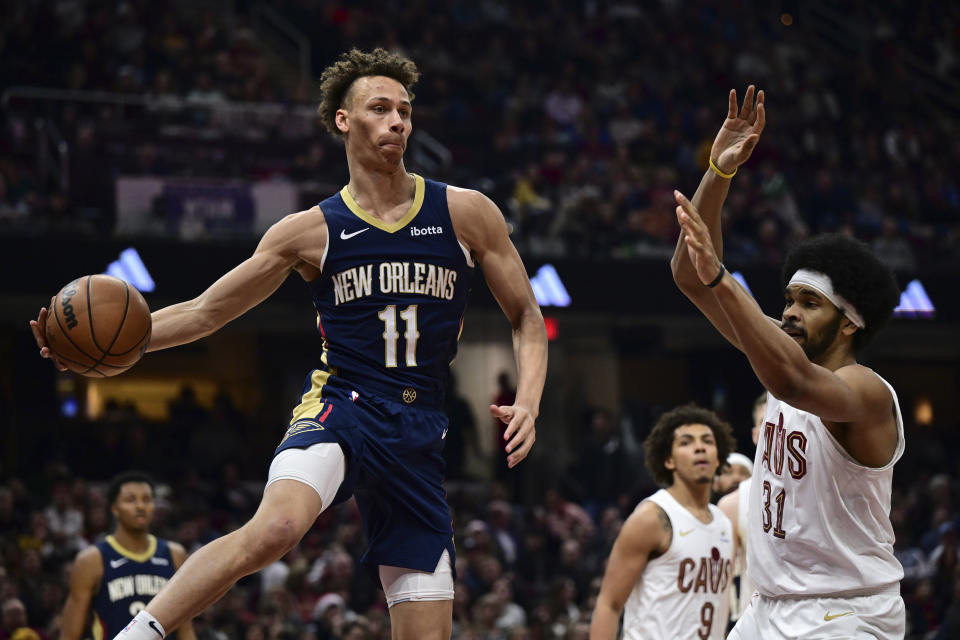 New Orleans Pelicans guard Dyson Daniels passes the ball against Cleveland Cavaliers center Jarrett Allen during the first half of an NBA basketball game Thursday, Dec. 21, 2023, in Cleveland. (AP Photo/David Dermer)