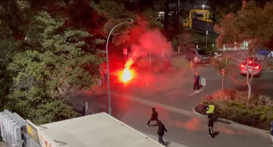 Soccer fans throwing flares and fighting outside Leichhardt Oval.