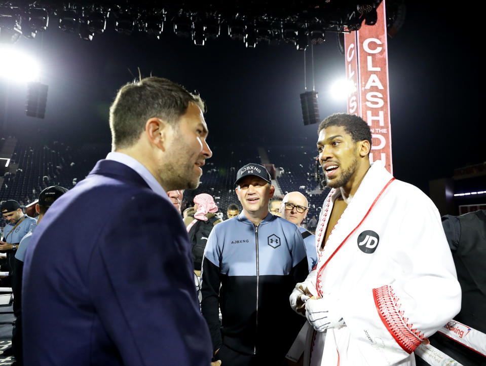 Anthony Joshua chats with promoters Eddie Hearn and Barry Hearn after regaining his IBF, WBA, WBO & IBO World Heavyweight title against Andy Ruiz