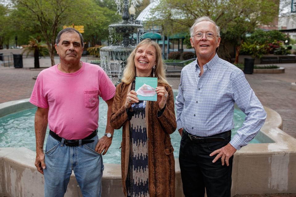 Singer-songwriter Frank Lindamood, poet, Dr. Donna Decker and composer Dr. James A. ÒAndyÓ Moorer pose for a photo together with Decker's book of poems at Kleman Plaza on Wednesday, March 23, 2022.