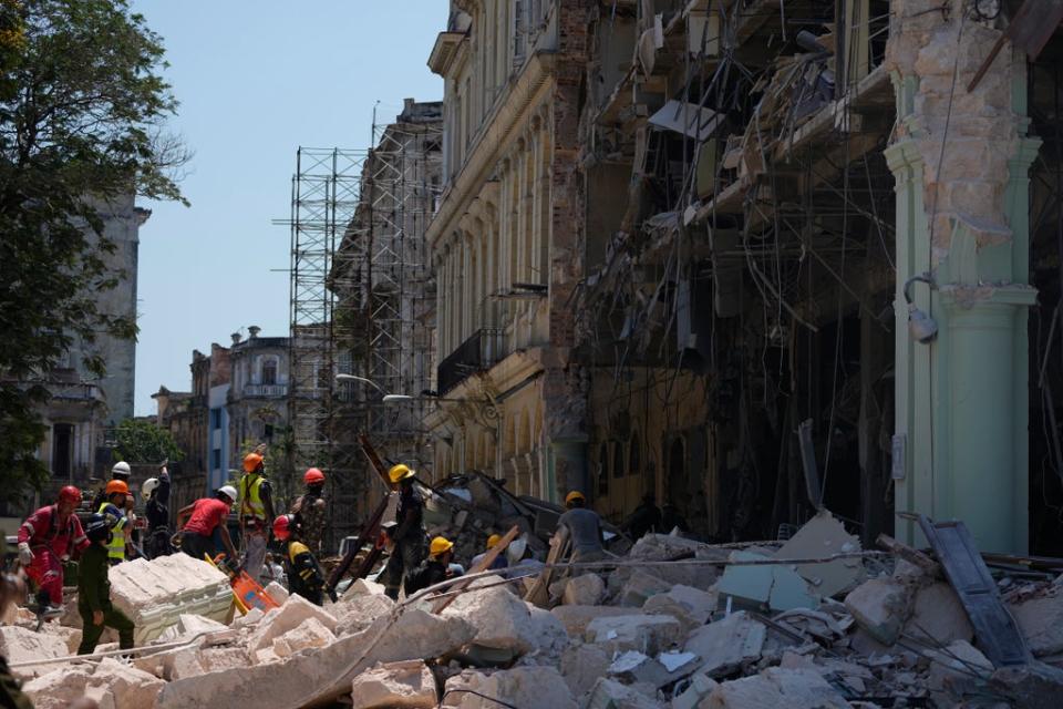 Emergency workers walk amid the rubble outside the five-star Hotel Saratoga after a deadly explosion in Old Havana, Cuba, Friday, May 6, 2022 (AP)