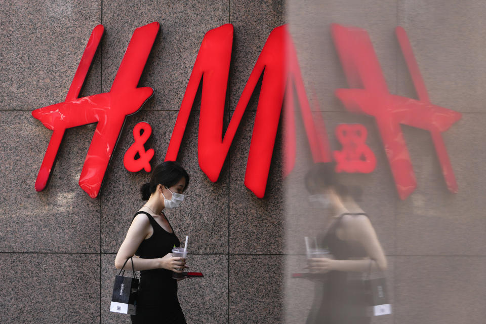 A woman walks by a Sweden-based clothing company H&M at a shopping mall in Beijing, Wednesday, June 21, 2023. Foreign companies are shifting investments and their Asian headquarters out of China as confidence plunges following the expansion of an anti-spying law and other challenges, a business group said Wednesday. (AP Photo/Andy Wong)