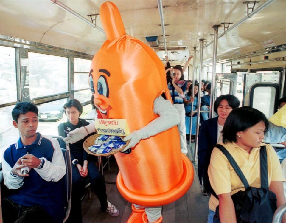 "Condom Man" passes out free condoms and HIV/AIDS awareness leaflets to bus passengers on Dec. 1, 1999, in Bangkok.  The leaflets and free condoms passed out are part of an HIV/AIDS awareness program in support of World AIDS day.