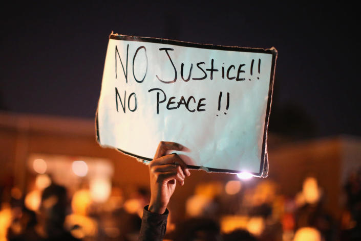 <p>Demonstrators protest the killing of teenager Michael Brown on August 12, 2014 in Ferguson, Missouri. Brown was shot and killed by a police officer on Saturday in the St. Louis suburb of Ferguson. Ferguson has experienced two days of violent protests since the killing but, tonight’s protest was peaceful. (Scott Olson/Getty Images) </p>