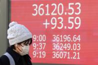 A person walks in front of an electronic stock board showing Japan's Nikkei 225 index at a securities firm Tuesday, Jan. 30, 2024, in Tokyo. Asian shares were mixed on Tuesday, with Hong Kong and Shanghai leading declines, ahead of a decision by the Federal Reserve this week on interest rates. (AP Photo/Eugene Hoshiko)