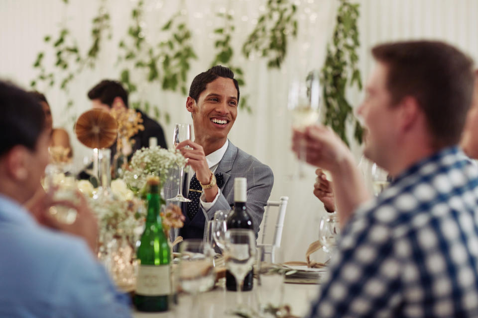 people raising their champagne glasses at a table