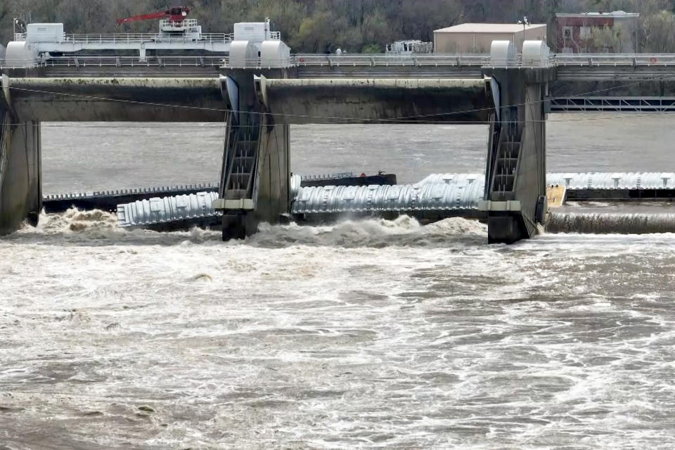 A barge that broke free from a tugboat on the Ohio River in Louisville, Ky., remained pinned against structures Tuesday. (WAVE)