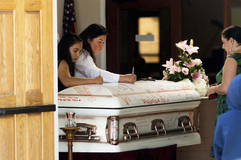 Mourners write on Keyla Salazar's casket during the 13-year-old's funeral on Tuesday, Aug. 6, 2019, in San Jose, Calif. Salazar and two others were killed when a gunman opened fire at the Gilroy Garlic Festival July 28. (AP Photo/Noah Berger)